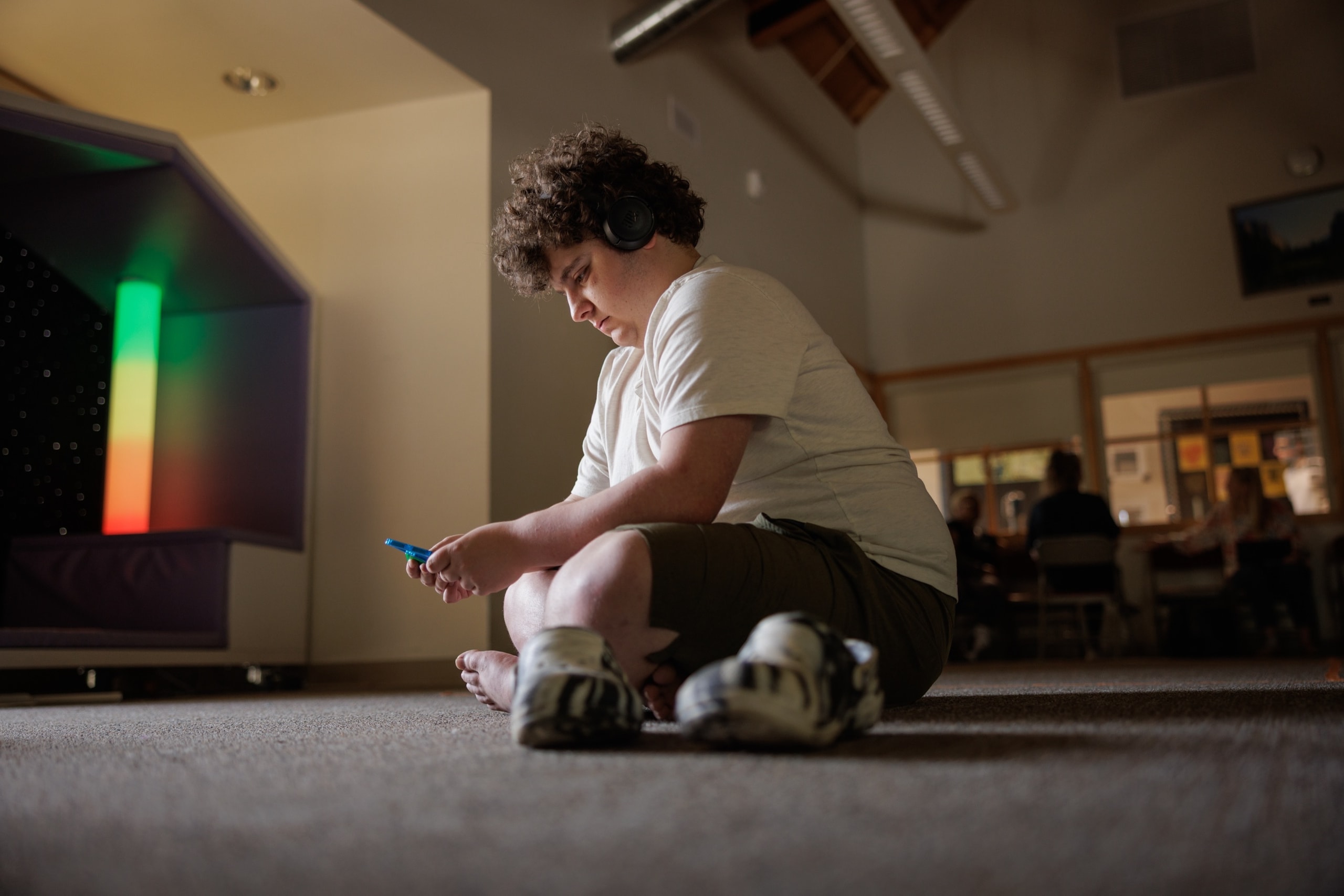 Student sitting near sensory lights in the sensory room