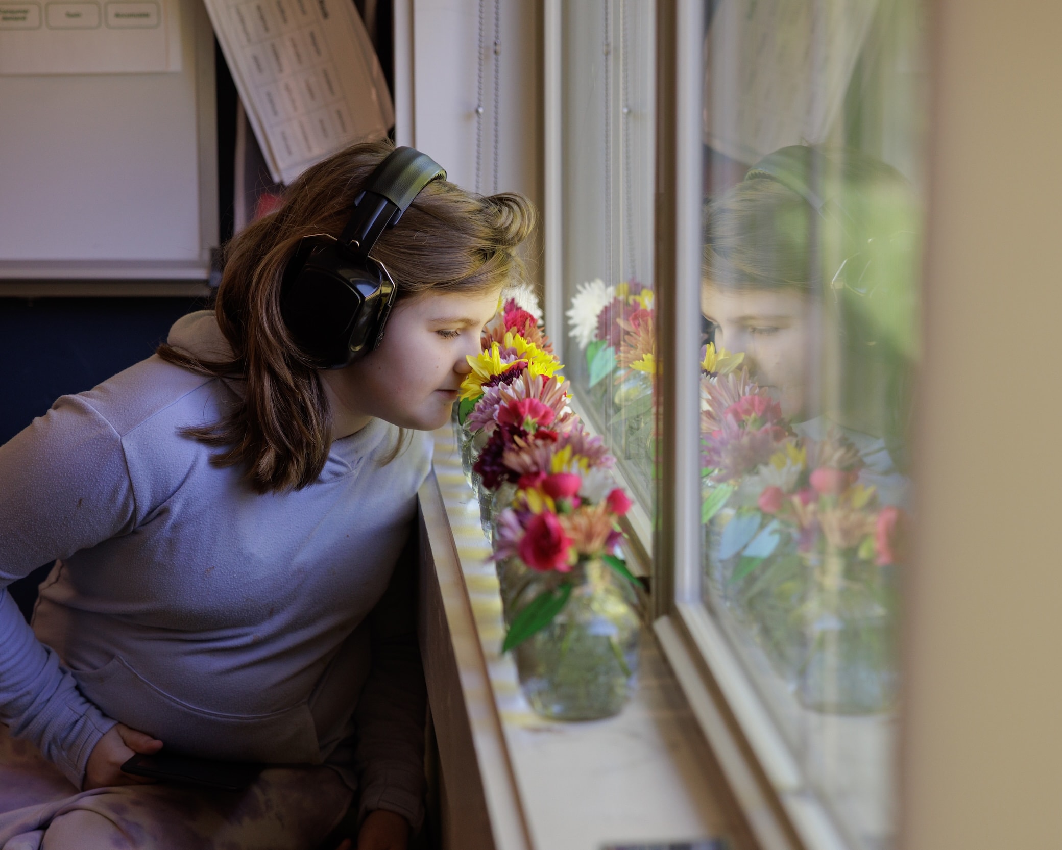 Student wearing headphones near a decorated window